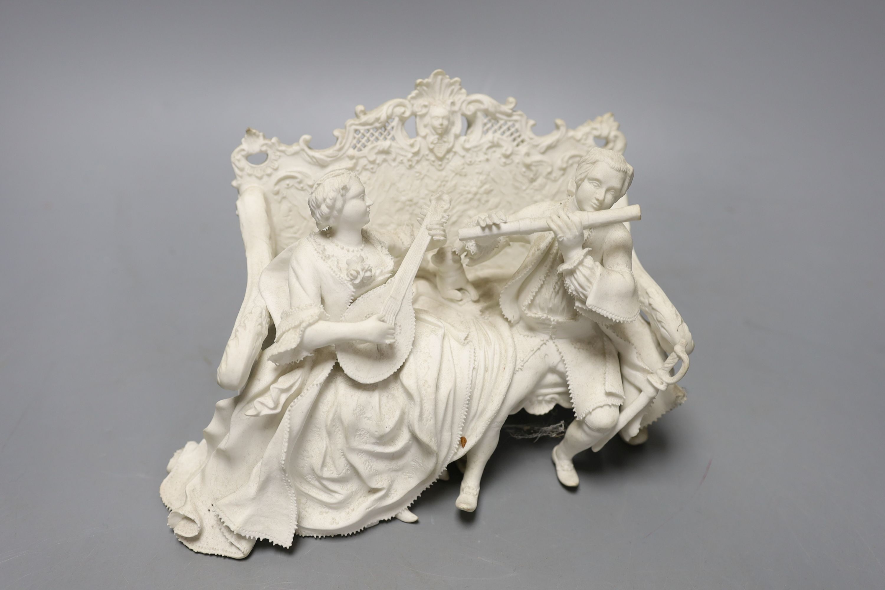 19th century English biscuit group of a woman with a mandolin and a man with a flute seated on an elaborate settee, 20 cm wide